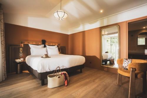 a hotel room with a large bed and a mirror at Parc Victoria Appartements in Saint-Jean-de-Luz