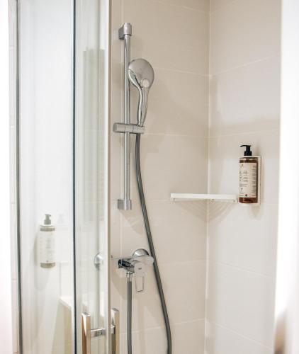 a shower with a shower head in a bathroom at Résidence Bordeaux Sud Pessac in Pessac