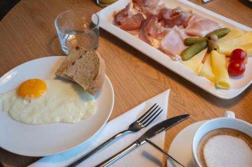 a table with a plate of food with eggs and bread at Suites DANICA in Šmartno