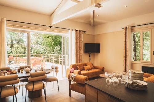 a living room with a table and chairs and a living room at Parc Victoria Appartements in Saint-Jean-de-Luz