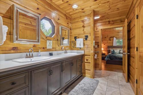 a bathroom with two sinks and a bedroom at Chasing Cubs Cabin By Beyond Expectations in Sevierville