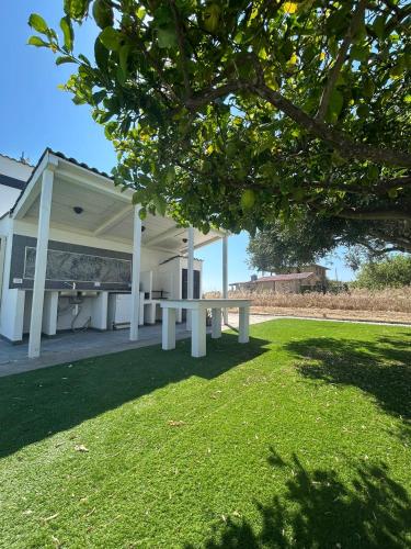 a white building with a picnic table in the grass at Villa Alena in Montallegro