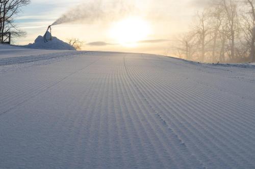 a snow covered slope with the sun setting in the background at Northridge 07 With Wintergreen Advantage in Roseland