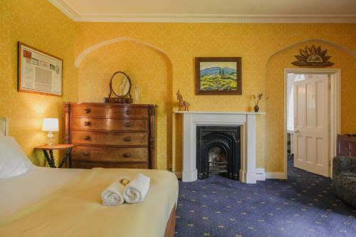 Un dormitorio con una cama y una chimenea. en Rural Victorian Mansion, en Wrington