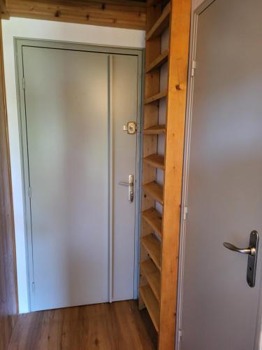 une porte menant à un placard avec des étagères en bois dans l'établissement Studio Mezzanine Les Combettes E, aux Contamines-Montjoie