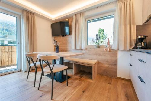 a kitchen with a table and chairs and a window at Appartements Strutzer in Sillian