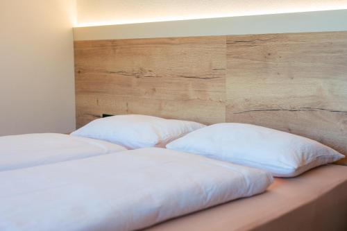 two white pillows sitting on a bed in a room at Appartements Strutzer in Sillian