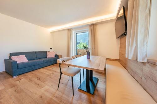 a living room with a blue couch and a table at Appartements Strutzer in Sillian