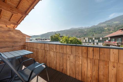 a wooden fence with a table and chairs on a deck at Appartements Strutzer in Sillian