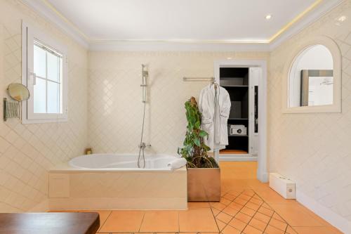 a large bathroom with a tub and a plant in it at Molo Luxury Suites Puerto Banus in Marbella