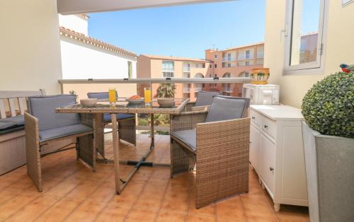 un patio avec une table et des chaises sur un balcon dans l'établissement Musa by POM, clim, terrasse, au Cap d'Agde