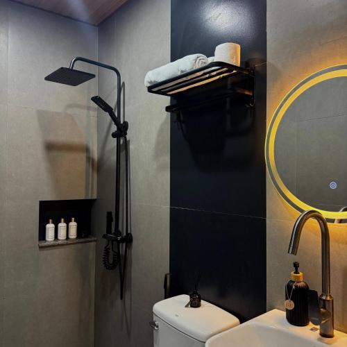 a bathroom with a toilet and a sink and a mirror at CASA KM Beach Pool Access in Dauis
