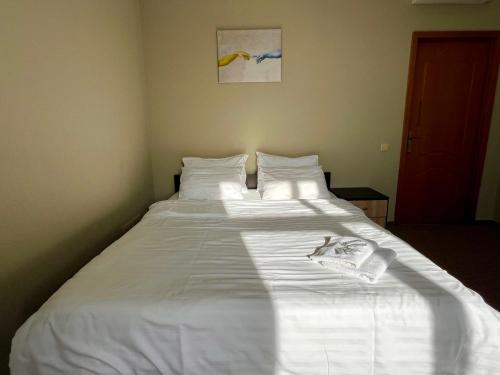 a large white bed in a small room at 4Room Hostel in Kyiv