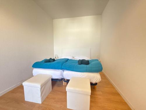 - une chambre avec un lit bleu et deux tabourets dans l'établissement Villa Bianca Appartement DUPLEX climatisé à 500m de la plage, à Sérignan