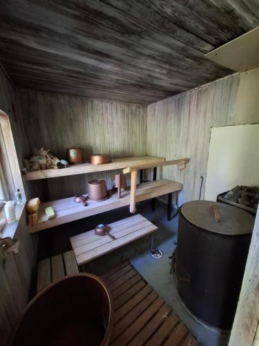 a small room with a wooden table and a barrel at Ahopelto in Savonlinna