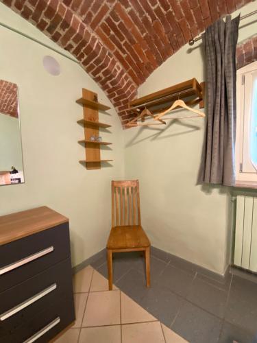a room with a chair and a brick ceiling at Villa Giulia - Bisalta in Peveragno