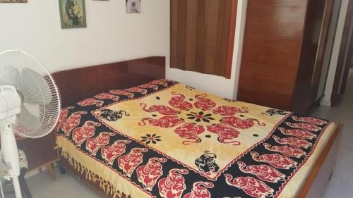 a bedroom with a bed with a blanket and a fan at Casa di Nonna in Calasetta