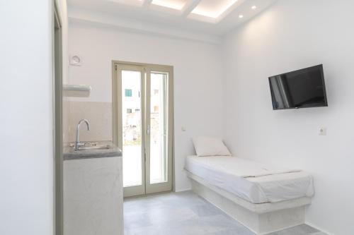 a white room with a bed and a tv at Depis castle in Naxos Chora