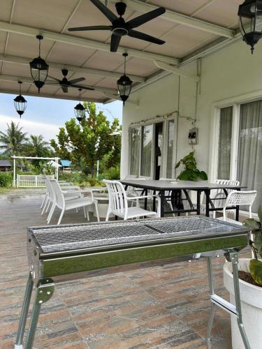 a patio with white chairs and a table and a ceiling fan at Amicasa Homestay Seremban in Seremban