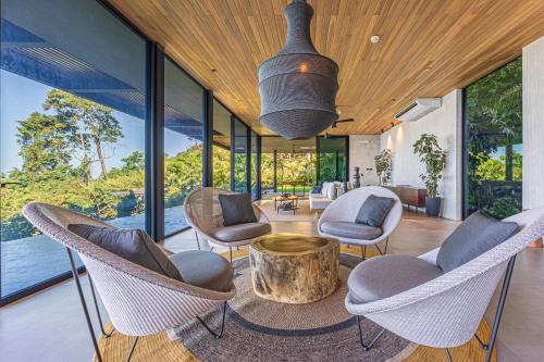 a living room with chairs and a table at Amazing View-25m75ft Pool-sleep 16-luxury-private in Dominical