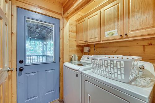 a laundry room with a washing machine and a blue door at Hot Tub and Game Room Family Retreat in Broken Bow in Broken Bow