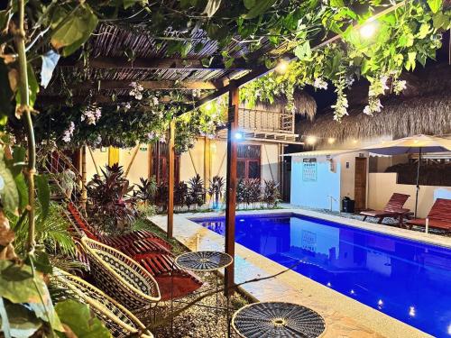 a swimming pool with chairs and an umbrella at Rincon del Mar Palomino in Palomino