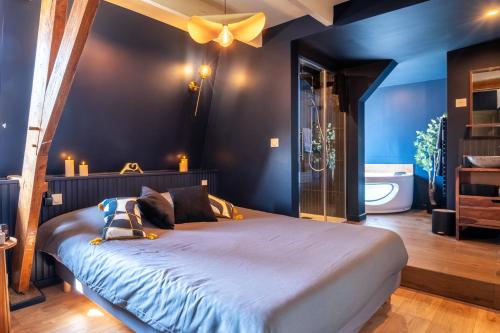a bedroom with a large bed and a bathroom at Au Cheval Noir in Quaëdypre