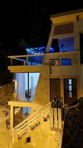 a house with a staircase in front of it at night at Kotor Bay View Apartments in Bijela