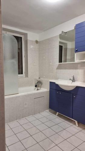 une salle de bain avec une baignoire, un lavabo et un miroir dans l'établissement Grande maison idéale réunions familiales, à Nervieux