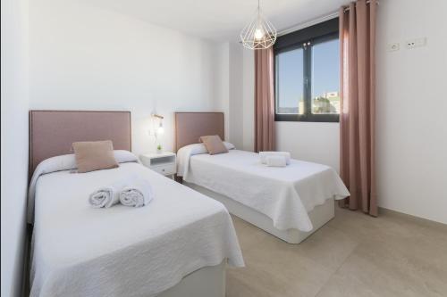 a bedroom with two beds and a window at AG El Alamo in Playa de Gandia