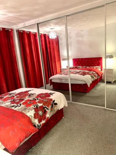 a bedroom with two beds and red curtains at Lovely accommodation closer to the beach in Hartlepool
