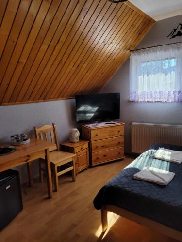扎科帕内Kowali Wierch的配有床、桌子和电视的房间