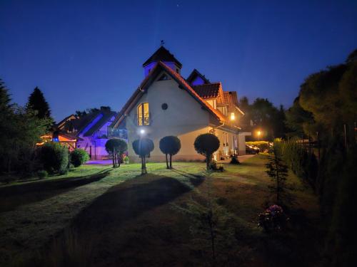 a large white house at night with lights at Noclegi Węgierska Górka in Węgierska Górka