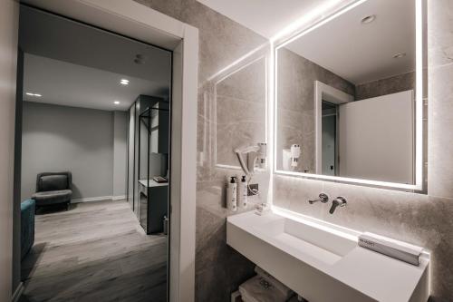 a bathroom with a sink and a mirror at Boe Luxury Hotel in Sarandë