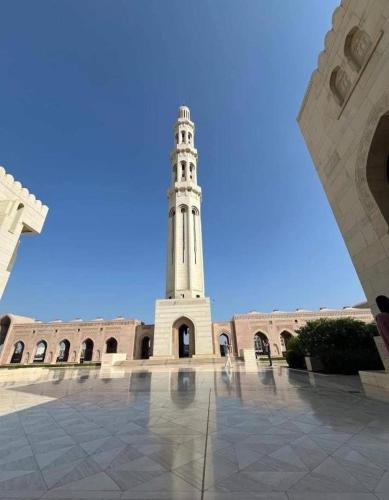 a large building with a clock tower in the background at international hoste in Muscat