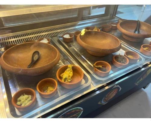 a display case with bowls of food and utensils at international hoste in Muscat