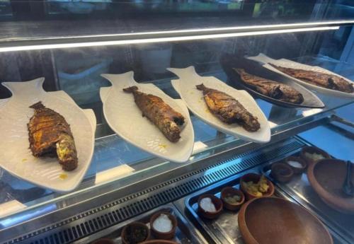 a display case with several different types of food at international hoste in Muscat