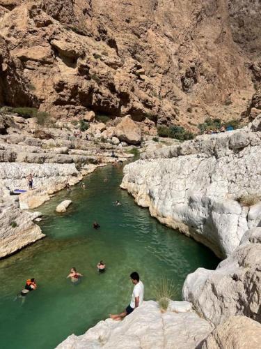 a group of people swimming in a river at international hoste in Muscat