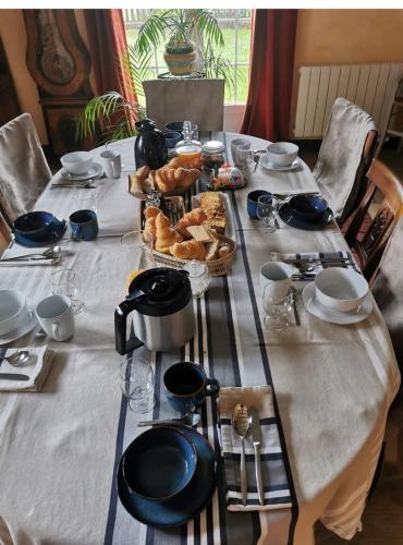 une longue table recouverte d'une nappe blanche sur laquelle sont disposées des pâtisseries dans l'établissement Au verger de la Pommeraye, à Morgny-la-Pommeraye