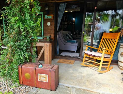 LedenikにあるGuesthouse Villa India - Bibliothekの家の外に椅子と一緒に置かれたスーツケース