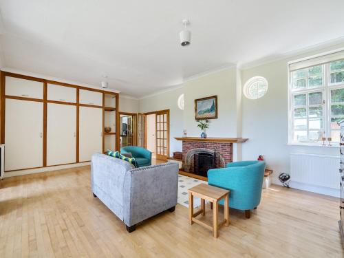 a living room with a couch and chairs and a fireplace at Surreys Secret Retreat for family & friends - Pass the Keys in Ottershaw