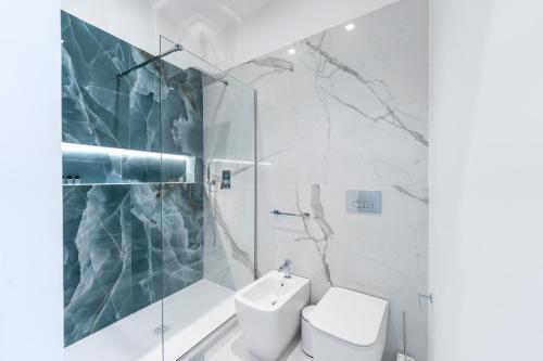 a white bathroom with a toilet and a shower at Alberti Apartments in Trapani