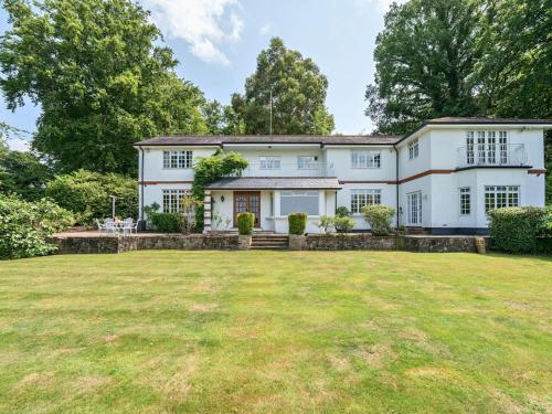 an exterior view of a white house with a large yard at Surreys Secret Retreat for family & friends - Pass the Keys in Ottershaw
