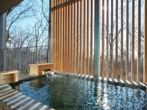 a swimming pool in a room with a large window at SANU 2nd Home Nasu 3rd in Nasu