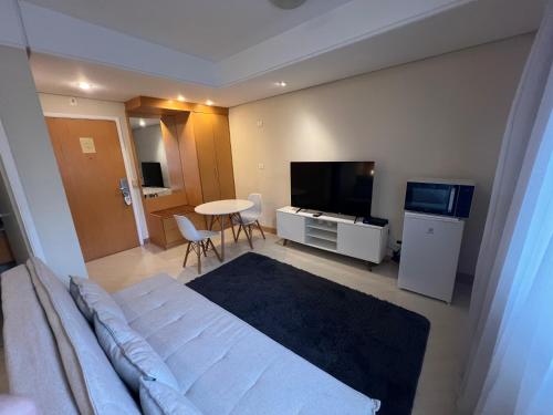a room with a bed and a table and a television at Hotel Biena Ibirapuera UH407 in Sao Paulo