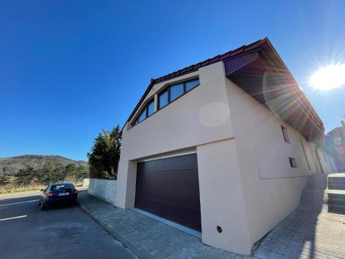 une voiture garée devant un immeuble avec garage dans l'établissement Apartment With a View, à Králŭv Dvŭr