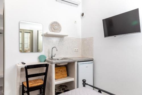 a small bathroom with a sink and a mirror at Depis castle in Naxos Chora