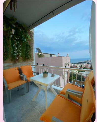 a balcony with orange chairs and a table on a balcony at Rafaela's Apartment in Kavala