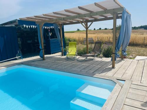 une piscine avec une terrasse en bois et une pergola dans l'établissement The Little House, à Saint-Simon-de-Bordes