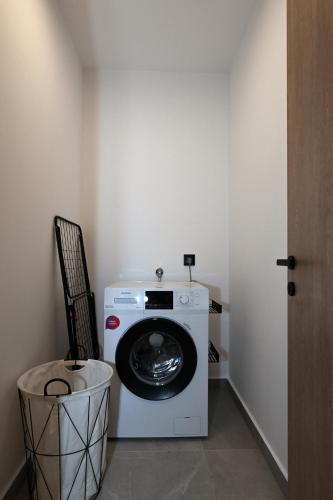 a washing machine in a room with a trash can at Agios Nikolaos Villas in Ayios Nikolaos Sithonia